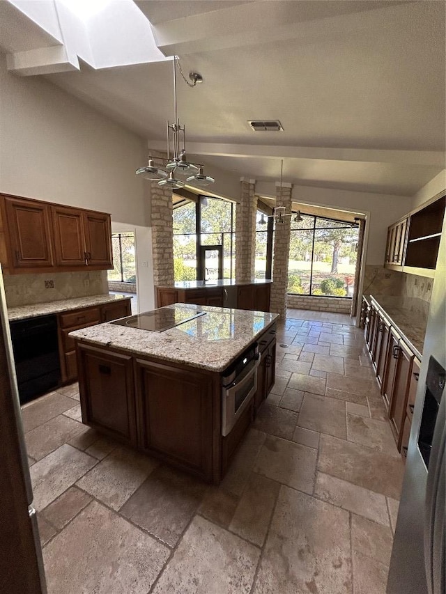 712 Rolling Green Dr, Lakeway, TX 78734 - kitchen featuring a center island, black electric cooktop, stone tile floors, and decorative backsplash