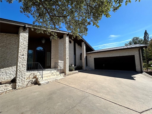 712 Rolling Green Dr, Lakeway, TX 78734 - view of home's exterior with brick siding, concrete driveway, and a garage