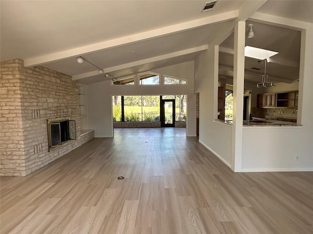 712 Rolling Green Dr, Lakeway, TX 78734 - unfurnished living room featuring a fireplace, wood finished floors, visible vents, baseboards, and beamed ceiling