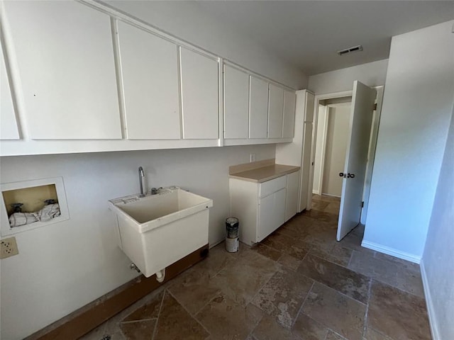 712 Rolling Green Dr, Lakeway, TX 78734 - laundry area featuring a sink, washer hookup, stone finish floor, visible vents, and cabinet space