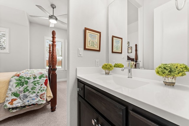 bathroom featuring ceiling fan, vanity, plenty of natural light, and baseboards
