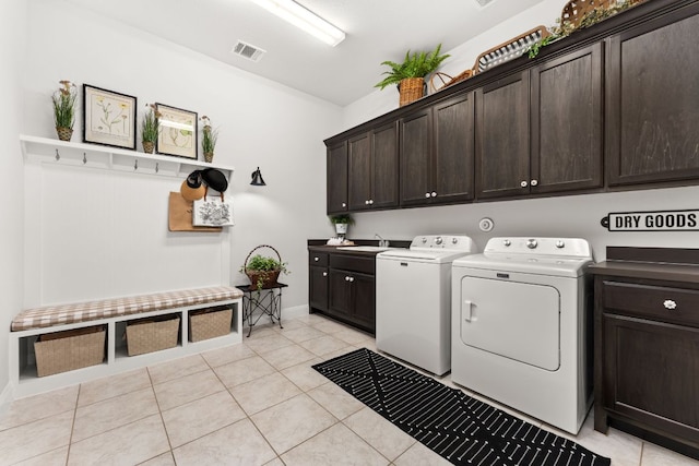 laundry area featuring washer and dryer, light tile patterned floors, cabinet space, baseboards, and visible vents