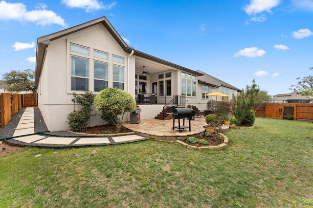 back of house featuring stucco siding, ceiling fan, a patio, and a fenced backyard