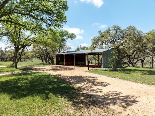 view of home's community featuring an outdoor structure, a pole building, and a yard