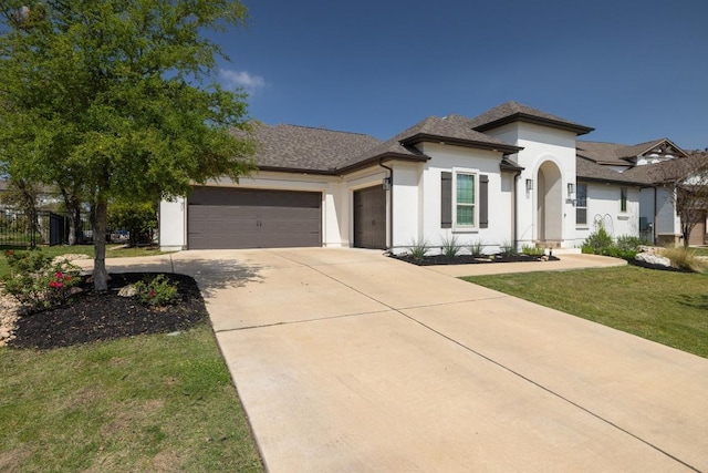 1924 Portobello Rd, Leander, TX 78641 - view of front facade with an attached garage, stucco siding, driveway, and a front lawn
