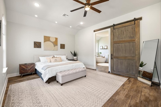 1924 Portobello Rd, Leander, TX 78641 - bedroom featuring a barn door, wood finished floors, lofted ceiling, recessed lighting, and connected bathroom