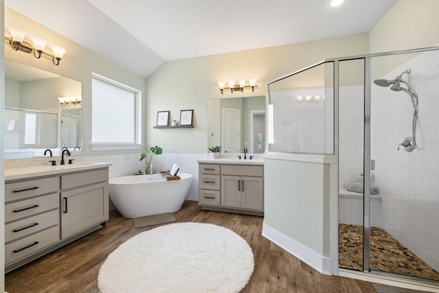 1924 Portobello Rd, Leander, TX 78641 - full bath featuring a shower stall, two vanities, a freestanding bath, lofted ceiling, and wood finished floors