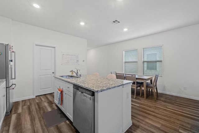 412 Gemsbok Rd, Hutto, TX 78634 - kitchen featuring stainless steel appliances, dark wood-style flooring, an island with sink, white cabinetry, and light stone counters