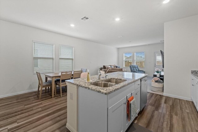 412 Gemsbok Rd, Hutto, TX 78634 - kitchen with dark wood finished floors, open floor plan, an island with sink, light stone countertops, and recessed lighting