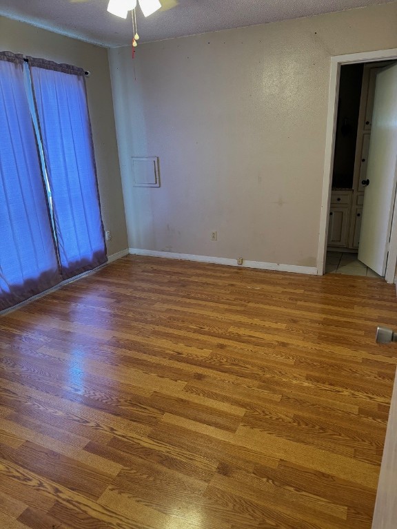 2100 Heights Blvd, Taylor, TX 76574 - empty room featuring wood finished floors, ceiling fan, and a textured ceiling