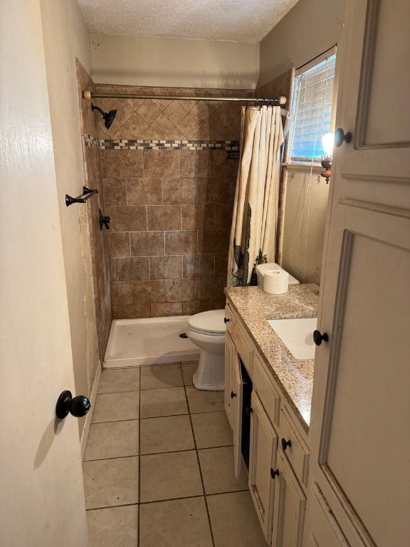 2100 Heights Blvd, Taylor, TX 76574 - full bath featuring tile patterned floors, vanity, a tile shower, and a textured ceiling