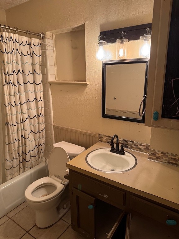 2100 Heights Blvd, Taylor, TX 76574 - bathroom featuring vanity, shower / tub combo with curtain, tile patterned floors, a textured wall, and wainscoting