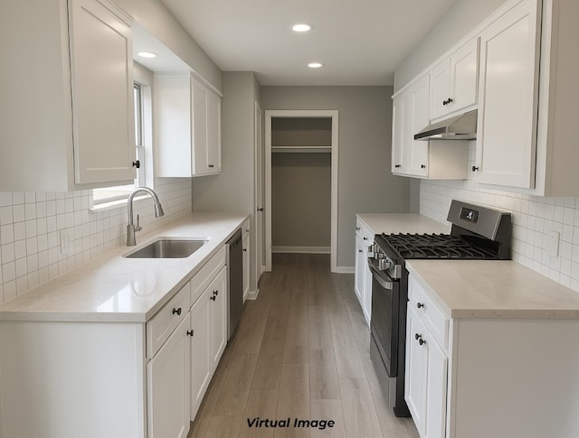 2100 Heights Blvd, Taylor, TX 76574 - kitchen with stainless steel appliances, under cabinet range hood, white cabinets, backsplash, and recessed lighting