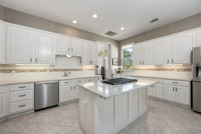 6 Radnor Dr, Austin, TX 78738 - kitchen featuring appliances with stainless steel finishes, tasteful backsplash, white cabinetry, a center island, and recessed lighting
