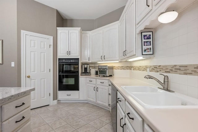 6 Radnor Dr, Austin, TX 78738 - kitchen featuring a sink, white cabinetry, stainless steel dishwasher, backsplash, and light tile patterned floors
