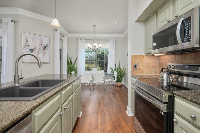 7701 Rialto Blvd Unit 617, Austin, TX 78735 - kitchen with appliances with stainless steel finishes, a sink, a chandelier, wood finished floors, and tasteful backsplash
