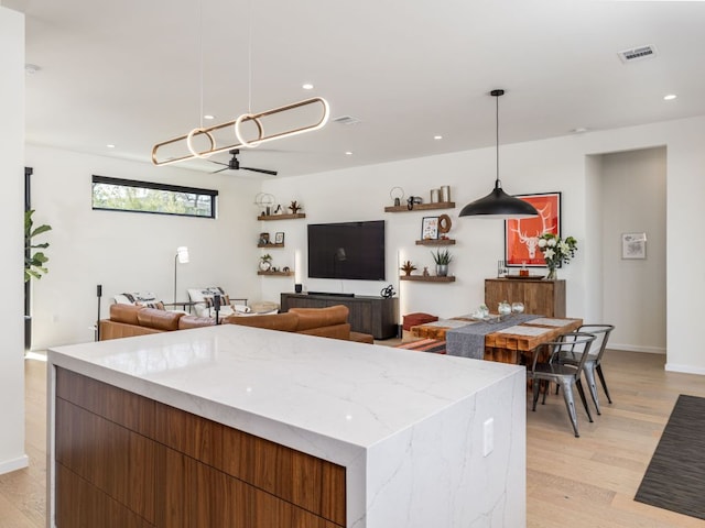 1510 Bellaire Dr, Austin, TX 78741 - kitchen featuring recessed lighting, modern cabinets, light wood finished floors, pendant lighting, and light stone countertops
