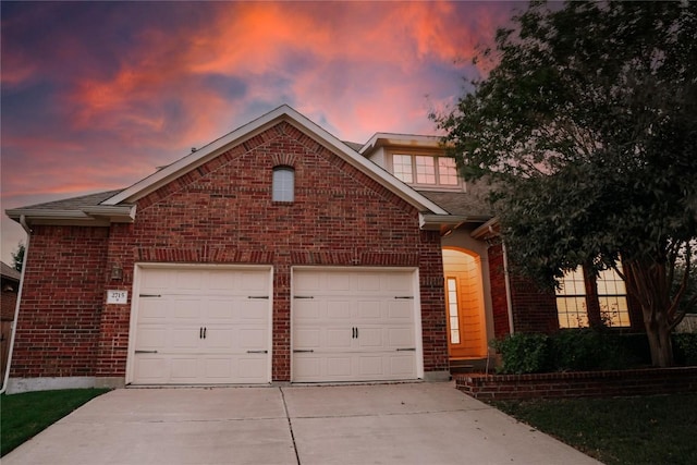 view of front facade with an attached garage, brick siding, and concrete driveway