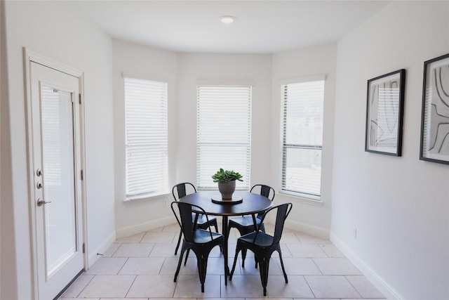 dining space featuring plenty of natural light, baseboards, and light tile patterned floors