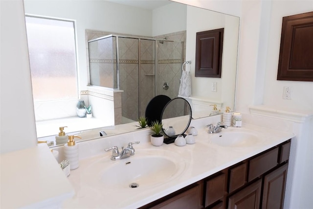 full bathroom with a stall shower, double vanity, and a sink