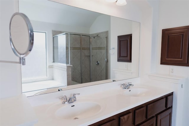 bathroom with double vanity, a sink, and a stall shower