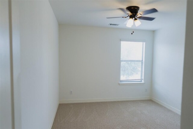 empty room featuring ceiling fan, baseboards, light colored carpet, and visible vents