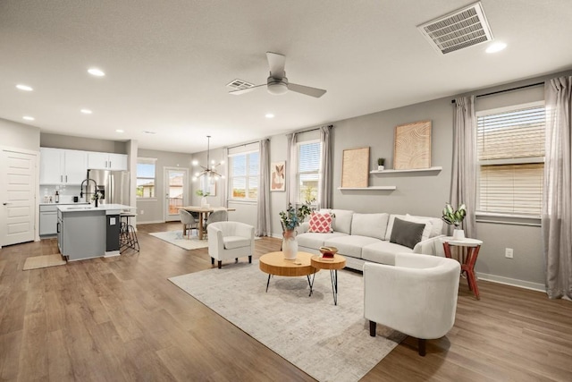 7800 Linnie Ln, Austin, TX 78724 - living area with a ceiling fan, recessed lighting, light wood-style floors, and a chandelier