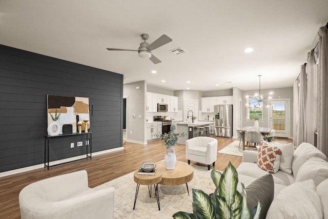 7800 Linnie Ln, Austin, TX 78724 - living room with light wood-style floors, a ceiling fan, a chandelier, and recessed lighting