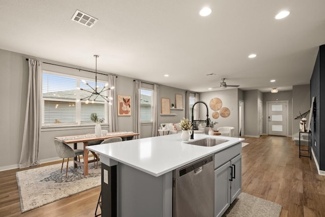 7800 Linnie Ln, Austin, TX 78724 - kitchen with dishwasher, a center island with sink, recessed lighting, wood finished floors, and a chandelier