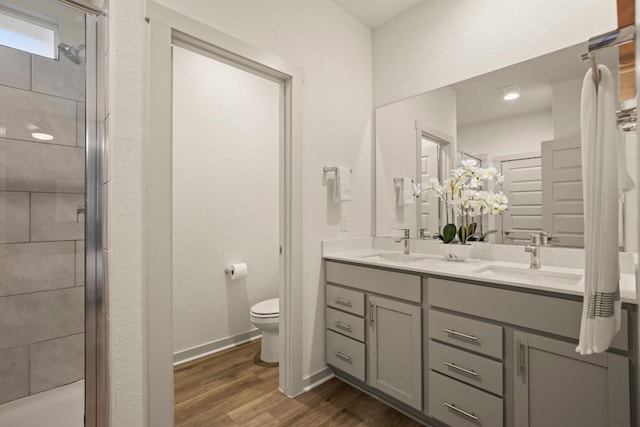 7800 Linnie Ln, Austin, TX 78724 - full bathroom featuring double vanity, a shower stall, and wood finished floors