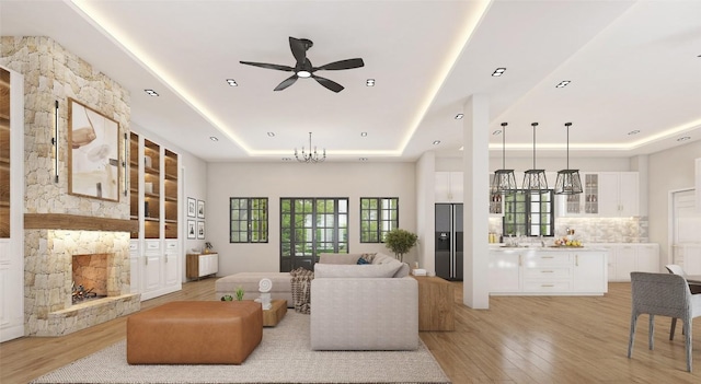 LOT47 E Flying Owl Dr, Johnson City, TX 78636 - living area featuring a fireplace, a tray ceiling, light wood-style floors, and ceiling fan