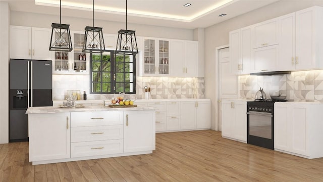 LOT47 E Flying Owl Dr, Johnson City, TX 78636 - kitchen featuring a kitchen island, a raised ceiling, glass insert cabinets, gas range, and black refrigerator with ice dispenser