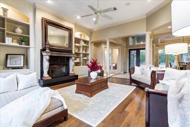 1317 Jack Nicklaus Cir, Salado, TX 76571 - living area featuring hardwood / wood-style floors, crown molding, built in features, and ornate columns