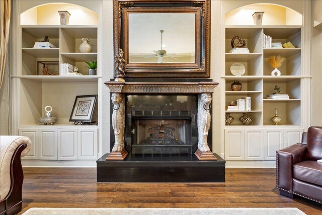 1317 Jack Nicklaus Cir, Salado, TX 76571 - living area featuring dark wood finished floors, built in shelves, and a ceiling fan