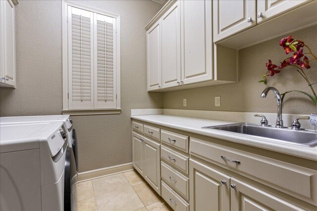 1317 Jack Nicklaus Cir, Salado, TX 76571 - laundry room featuring washer and clothes dryer, baseboards, a sink, light tile patterned flooring, and cabinet space