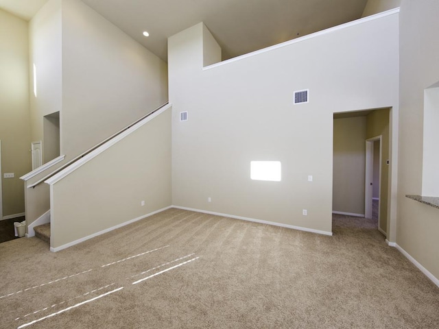 12110 Stoneridge Gap Ln, Manor, TX 78653 - unfurnished living room with a high ceiling, carpet floors, baseboards, stairway, and recessed lighting