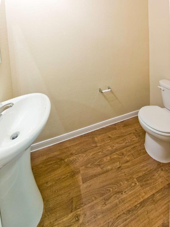 12110 Stoneridge Gap Ln, Manor, TX 78653 - bathroom featuring toilet, baseboards, and wood finished floors