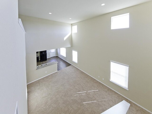 12110 Stoneridge Gap Ln, Manor, TX 78653 - unfurnished living room with healthy amount of natural light, carpet flooring, baseboards, recessed lighting, and a fireplace