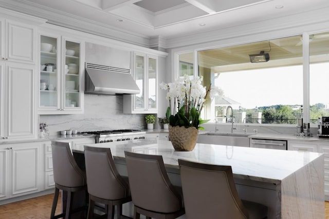 17 Cousteau Ln, Austin, TX 78746 - kitchen with extractor fan, white cabinetry, decorative backsplash, a breakfast bar, and ornamental molding