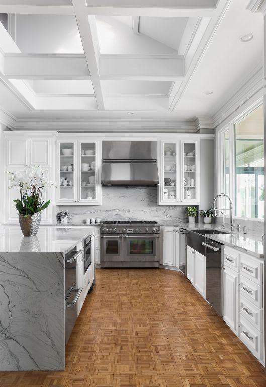 17 Cousteau Ln, Austin, TX 78746 - kitchen featuring appliances with stainless steel finishes, wall chimney range hood, white cabinetry, light stone counters, and tasteful backsplash