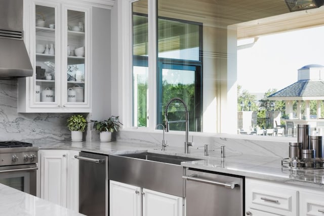 17 Cousteau Ln, Austin, TX 78746 - kitchen with stainless steel appliances, glass insert cabinets, light stone countertops, and white cabinets