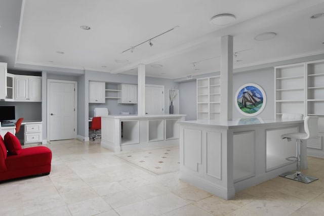 17 Cousteau Ln, Austin, TX 78746 - kitchen with open shelves, track lighting, a kitchen island, built in study area, and a kitchen breakfast bar