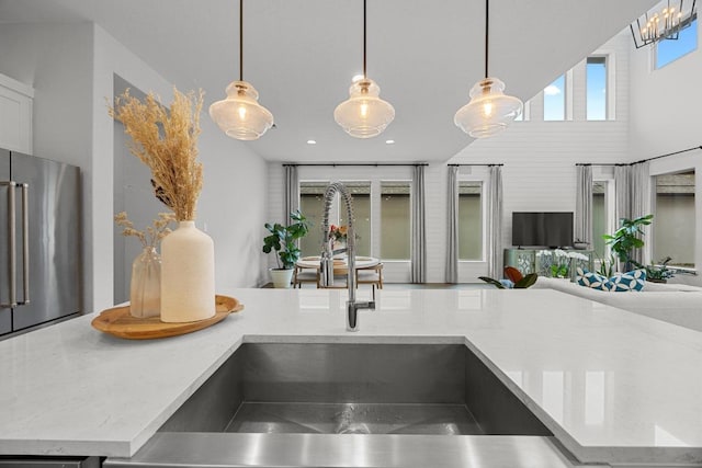 room details featuring decorative light fixtures, high quality fridge, a sink, and recessed lighting