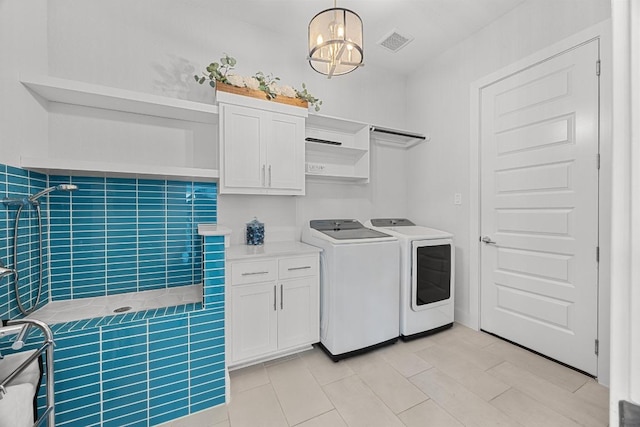 laundry area featuring cabinet space, an inviting chandelier, visible vents, and separate washer and dryer