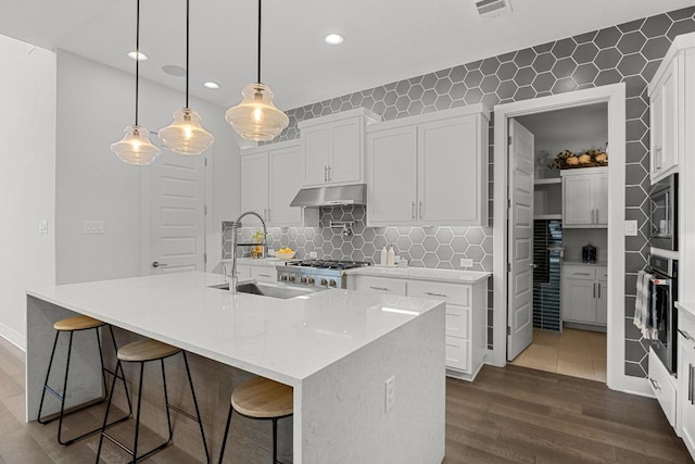 kitchen with recessed lighting, oven, white cabinets, a sink, and dark wood-style floors