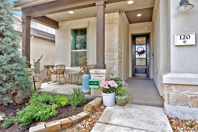 doorway to property featuring stone siding and stucco siding