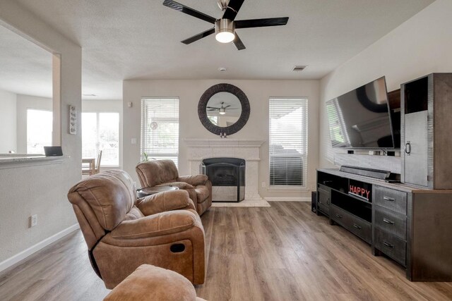 2209 Callaway Garden Ct, Pflugerville, TX 78660 - living room featuring a ceiling fan, a fireplace with raised hearth, and plenty of natural light