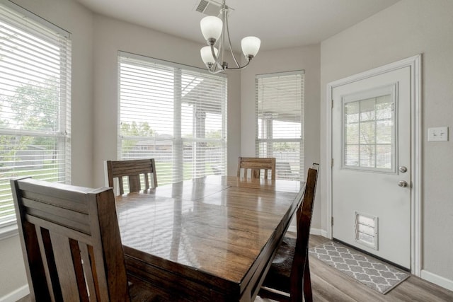 2209 Callaway Garden Ct, Pflugerville, TX 78660 - dining area with a chandelier, wood finished floors, and baseboards