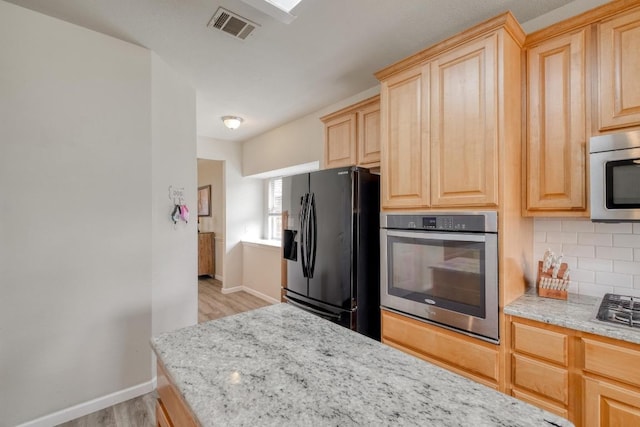 2209 Callaway Garden Ct, Pflugerville, TX 78660 - kitchen featuring stainless steel appliances, light brown cabinetry, baseboards, and light wood-style floors
