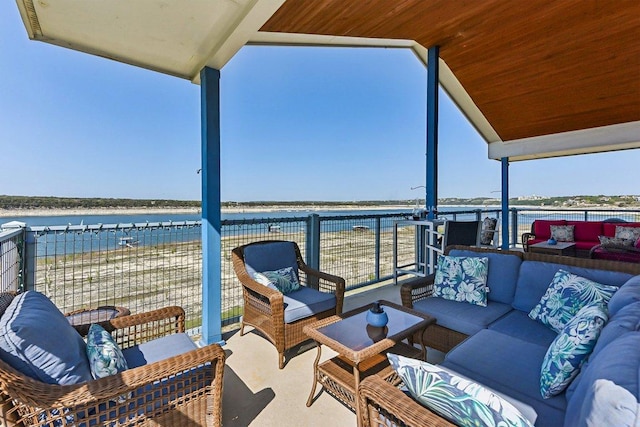 exterior space with outdoor lounge area, a balcony, and a water view